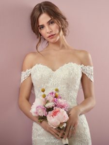 modem in an ivory wedding dress holding flowers